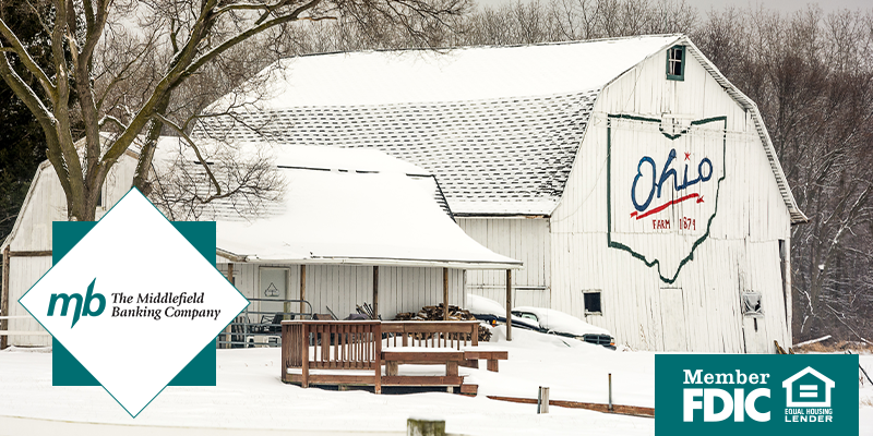 Snowy farm with the Ohio state logo on a white barn