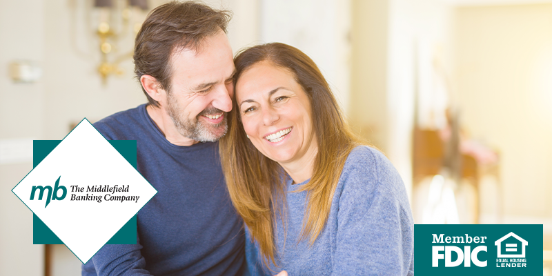 Older man and woman smiling and leaning into each other